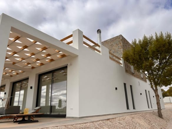 Villa exterior with a shaded terrace and sliding glass doors in Pinoso, Alicante