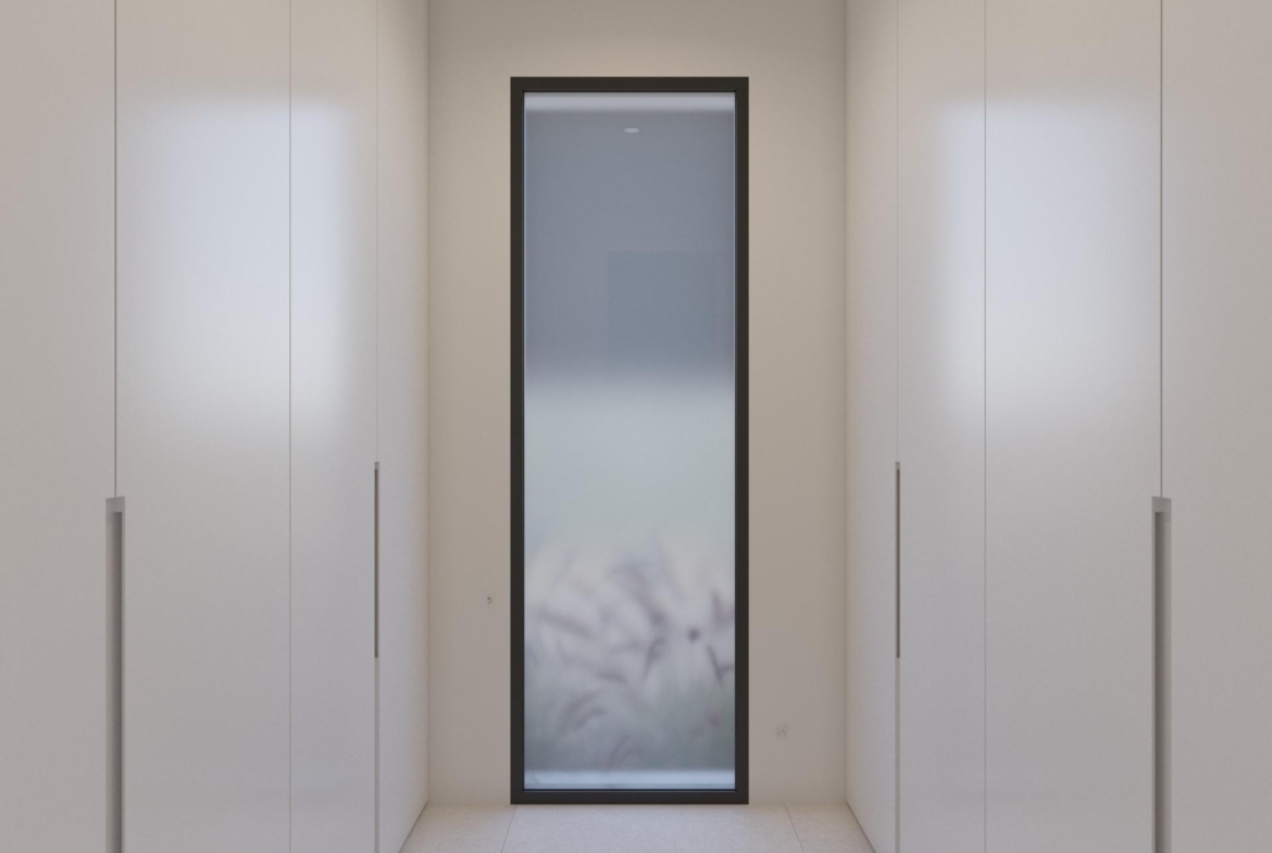Narrow dressing corridor with floor-to-ceiling wardrobes and tall frosted glass window at end