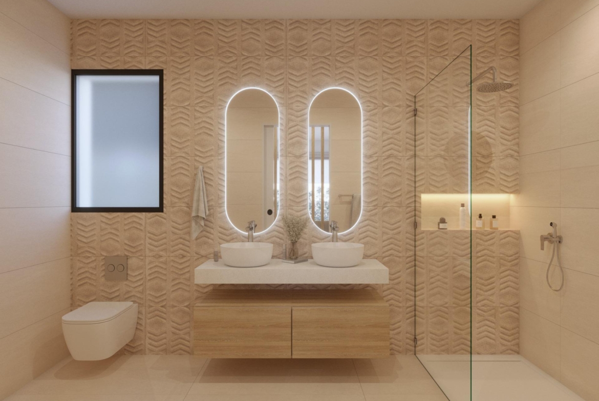 Bathroom with circular illuminated mirror, single basin and patterned tile wall