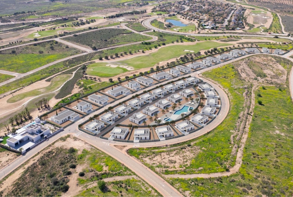 Aerial view showing curved residential enclave of new villas beside fairways and golf greens