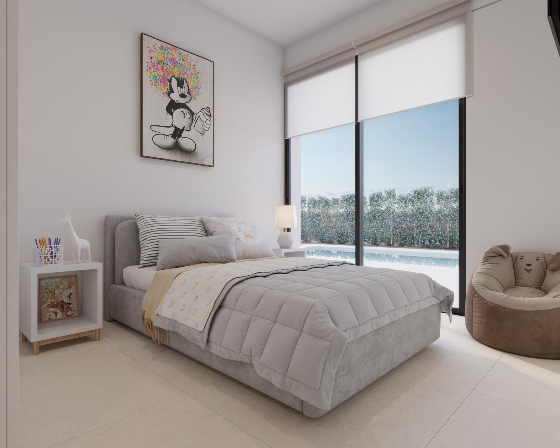 Guest bedroom with bed, bedside table and sliding doors opening to the pool area