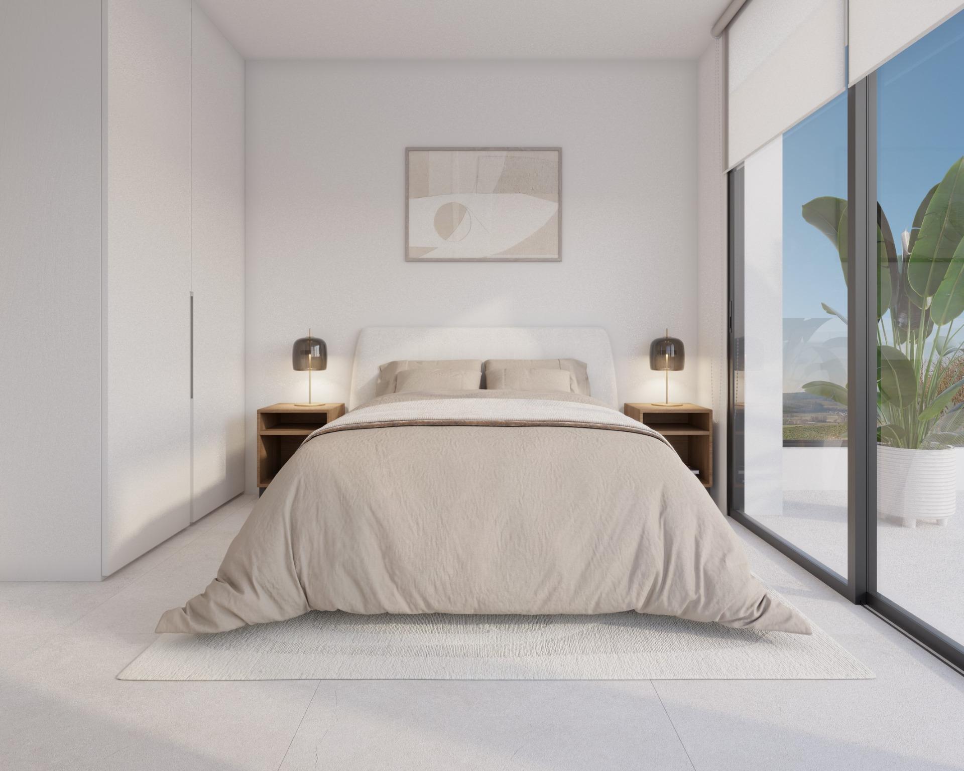 Bedroom corner with bed, shelving above and a chair beside window with blind