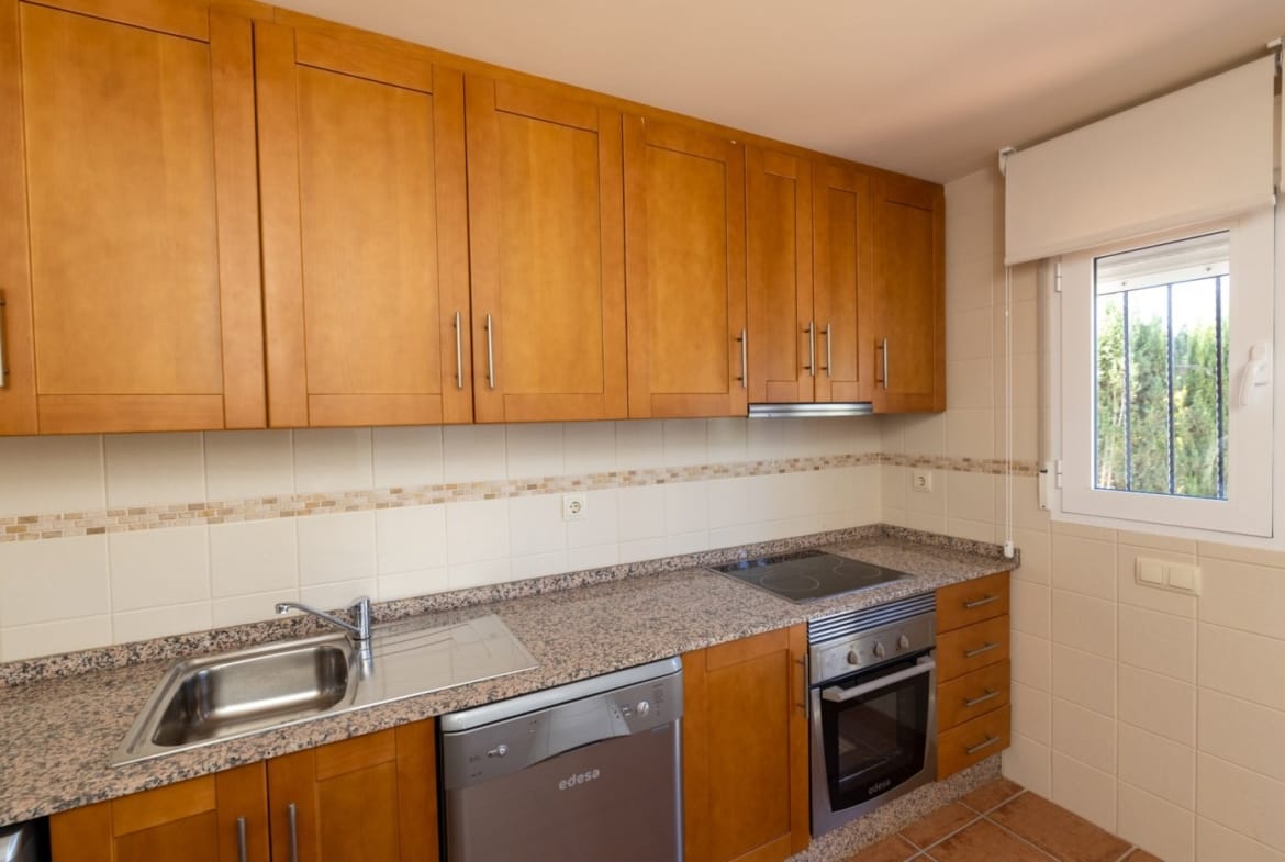 Kitchen with wooden cabinetry and a window above the worktop in Las Palas, Fuente Álamo, Murcia