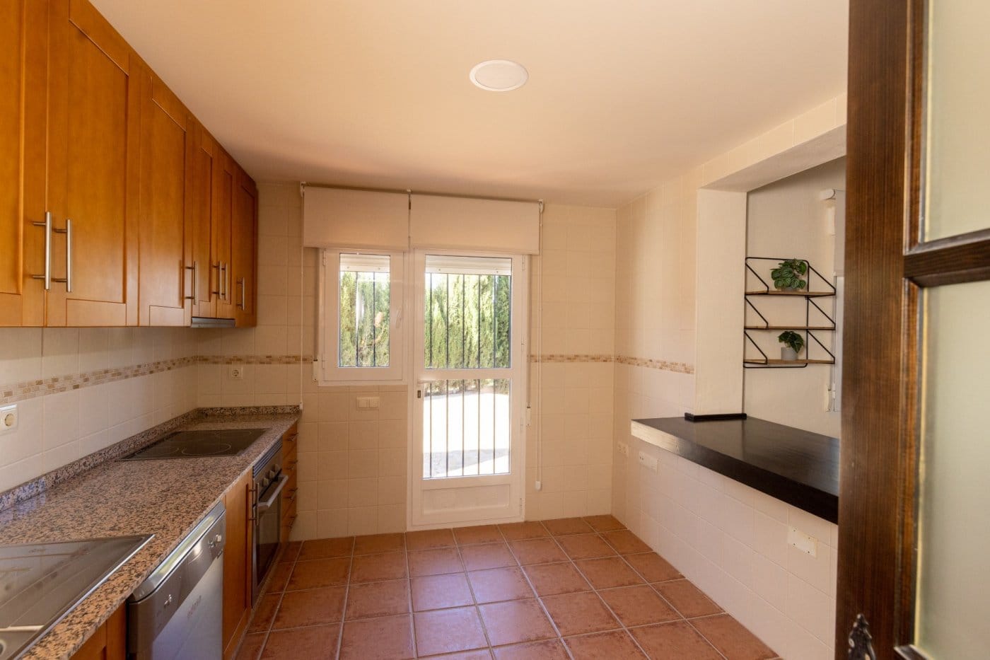 Kitchen with wood cabinets and a glazed door in Las Palas, Fuente Álamo, Murcia