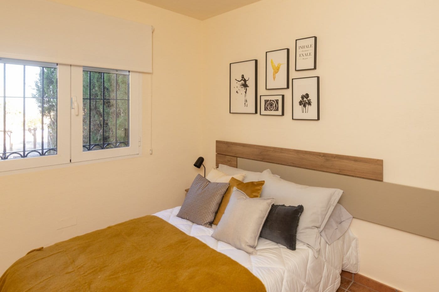 Double bedroom with a mustard bedspread and window in Las Palas, Fuente Álamo, Murcia
