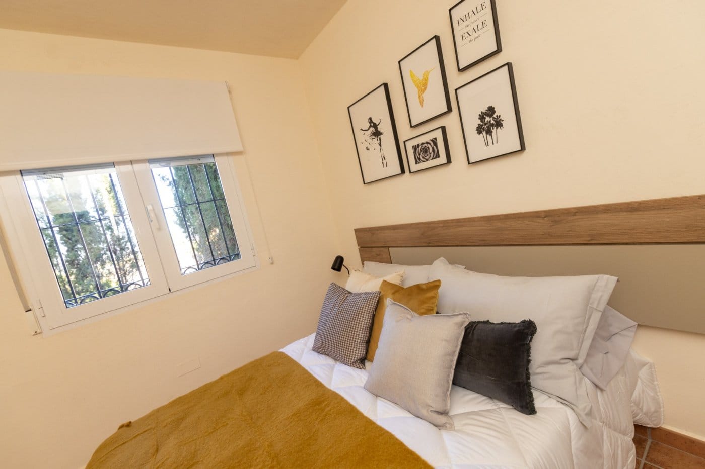Wooden headboard and framed prints in a double bedroom in Las Palas, Fuente Álamo, Murcia