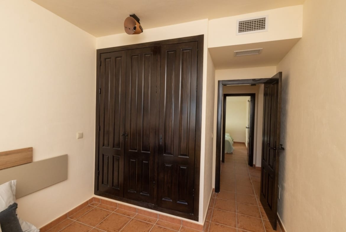 Dark fitted wardrobes and a doorway in a bedroom in Las Palas, Fuente Álamo, Murcia