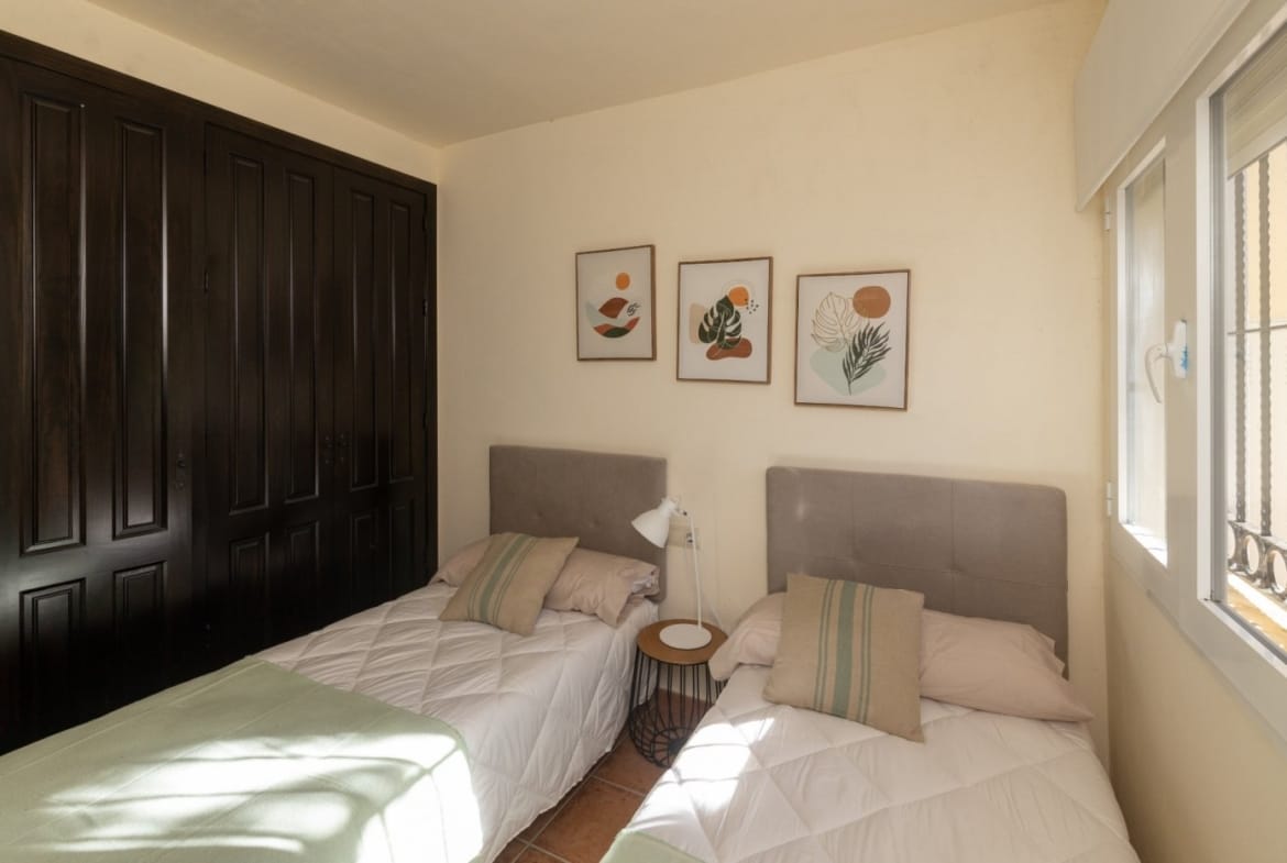 Twin beds beside dark wooden fitted wardrobes in Las Palas, Fuente Álamo, Murcia