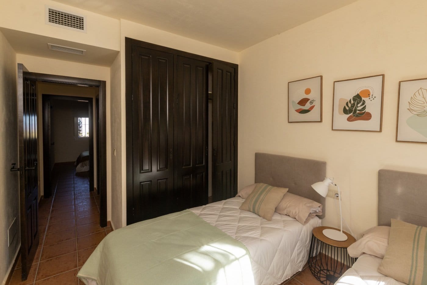 Twin beds beneath framed artwork beside a wardrobe in Las Palas, Fuente Álamo, Murcia