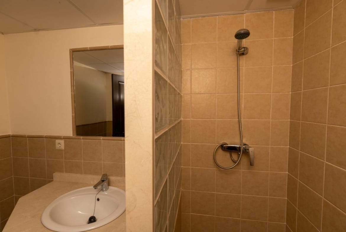 Shower enclosure with tan wall tiles and a dark shower fitting in Las Palas, Fuente Álamo, Murcia