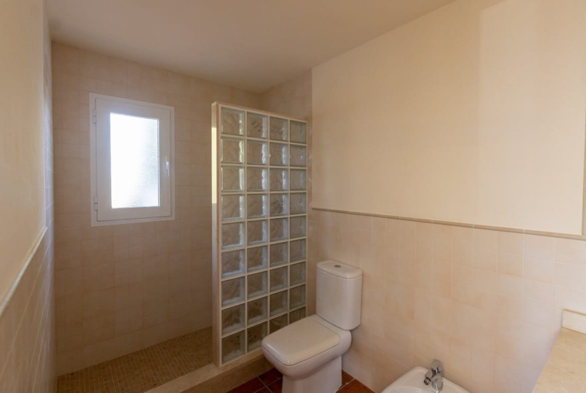 Bathroom with a glass-block shower screen and window in Las Palas, Fuente Álamo, Murcia
