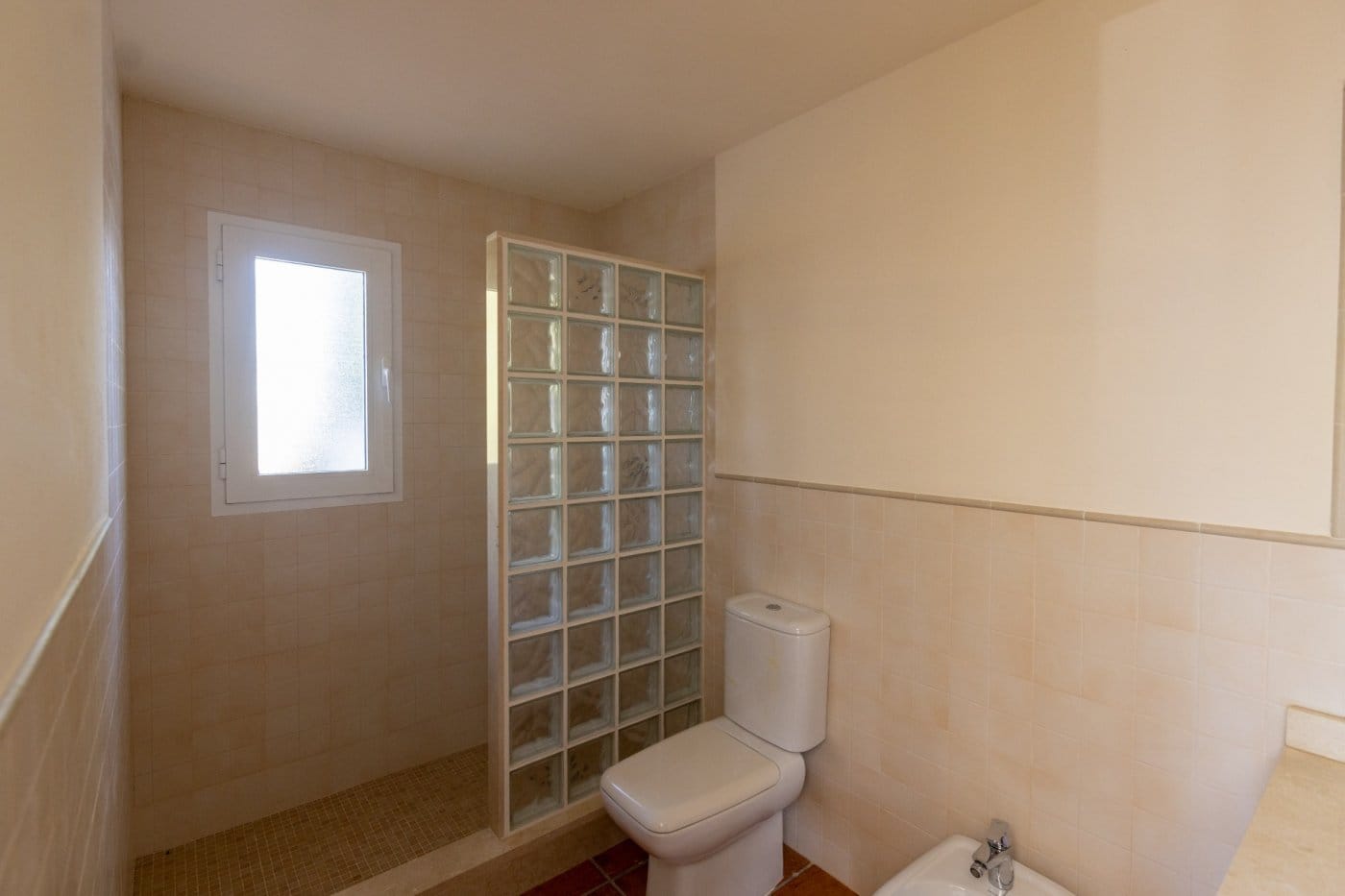 Bathroom with a glass-block shower screen and window in Las Palas, Fuente Álamo, Murcia