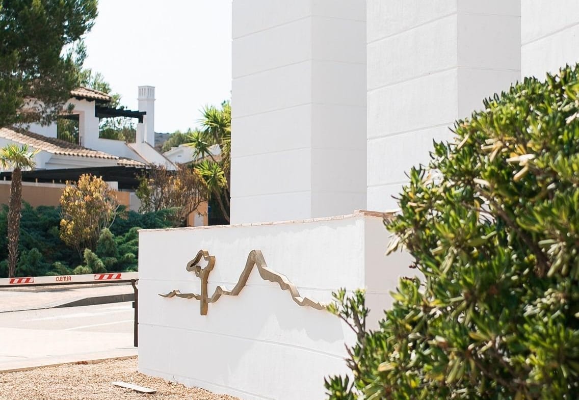 White entrance towers beside landscaped planting in Las Palas, Fuente Álamo, Murcia