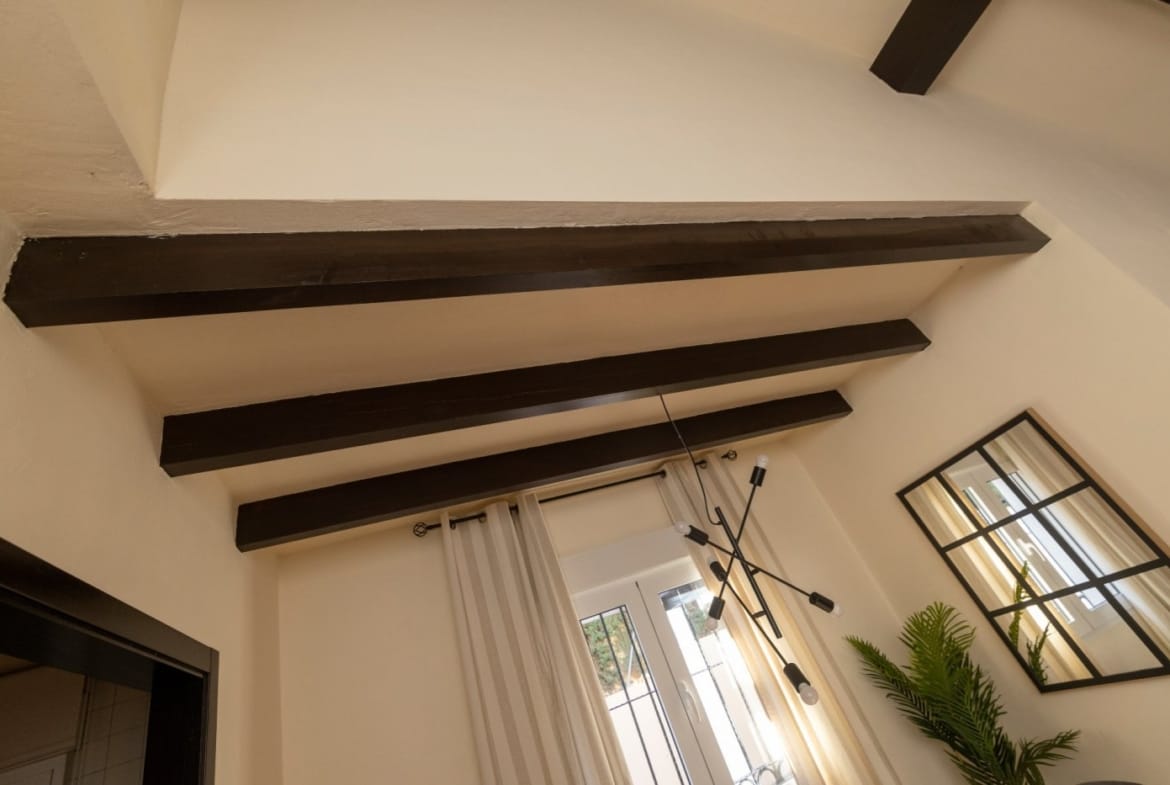 Timber beams above a dining area with a window and mirror in Las Palas, Fuente Álamo, Murcia