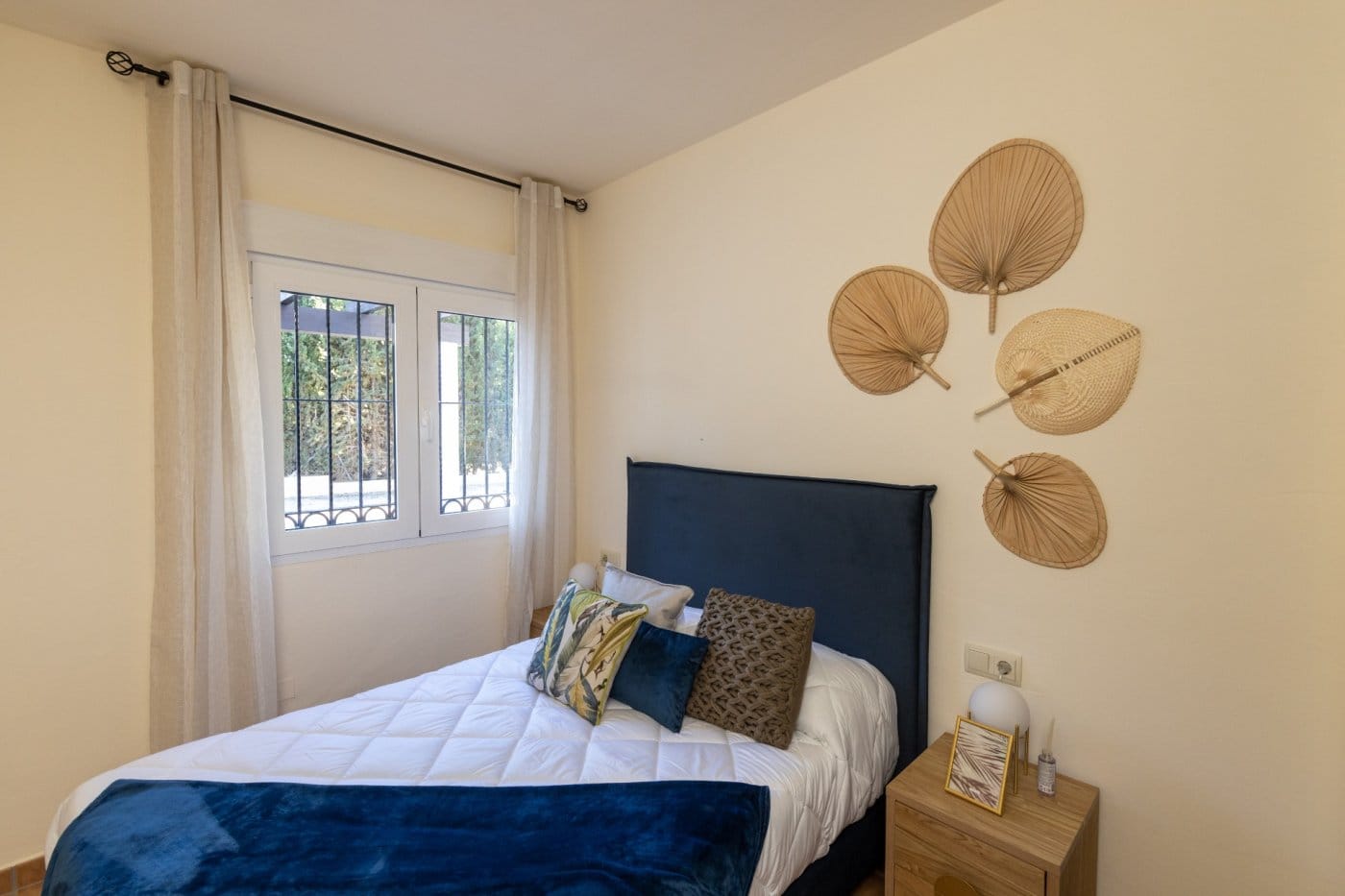 KEY-READY-VILLA-IN-FUENTE-ALAMO-MURCIA-25 Double bed with a blue throw beside a curtained window in Las Palas, Fuente Álamo, Murcia