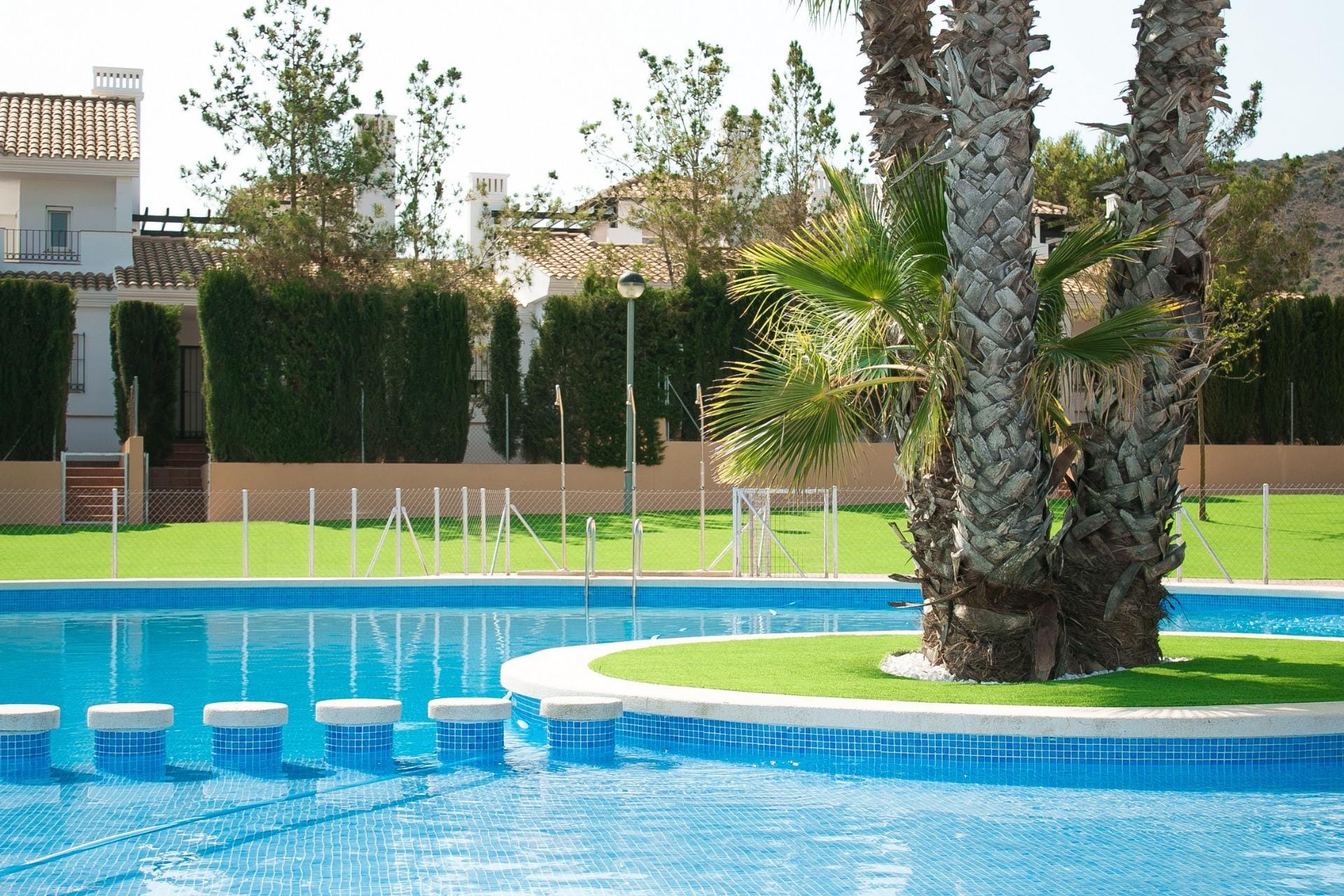 KEY-READY-VILLA-IN-FUENTE-ALAMO-MURCIA-3 Communal pool with a palm-planted island and stepping stones in Las Palas, Fuente Álamo, Murcia