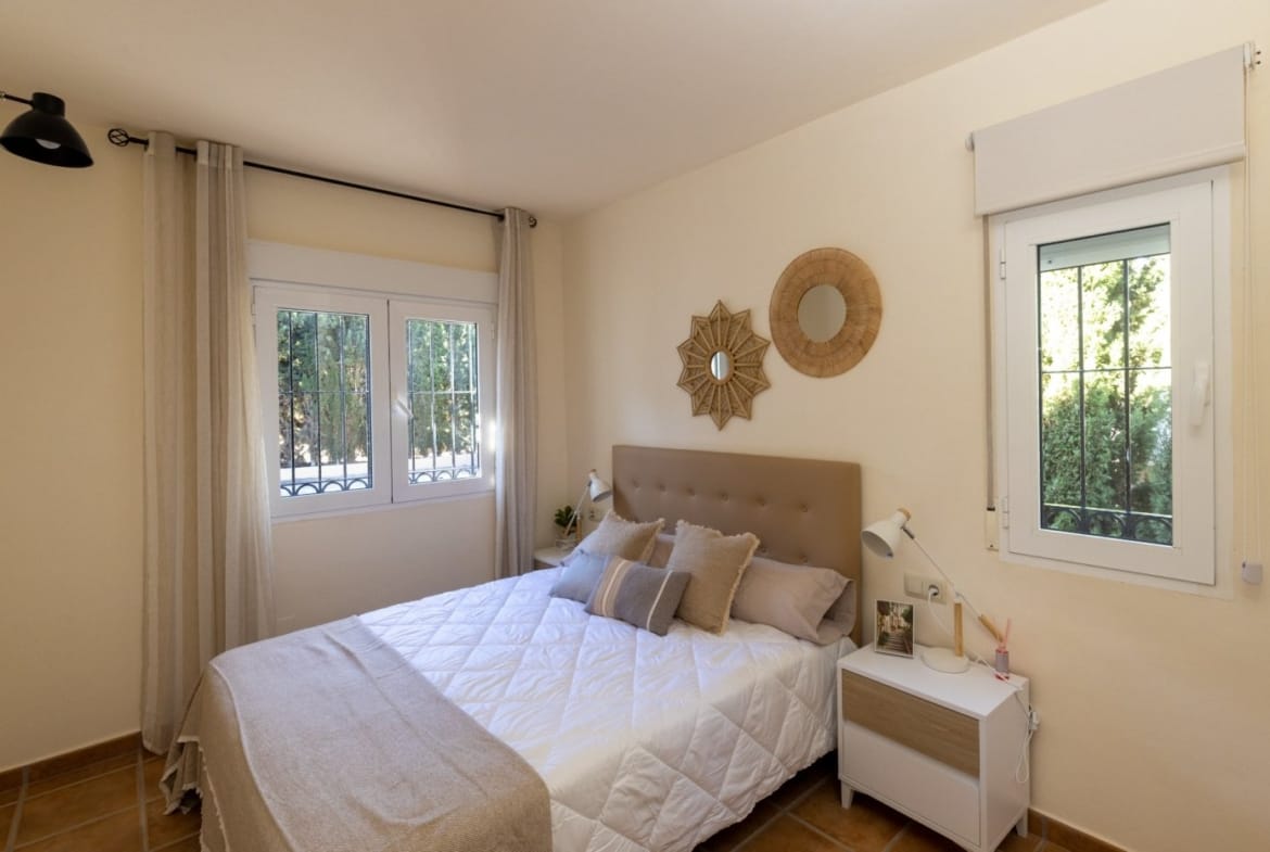 Double bedroom with woven wall decorations and two windows in Las Palas, Fuente Álamo, Murcia