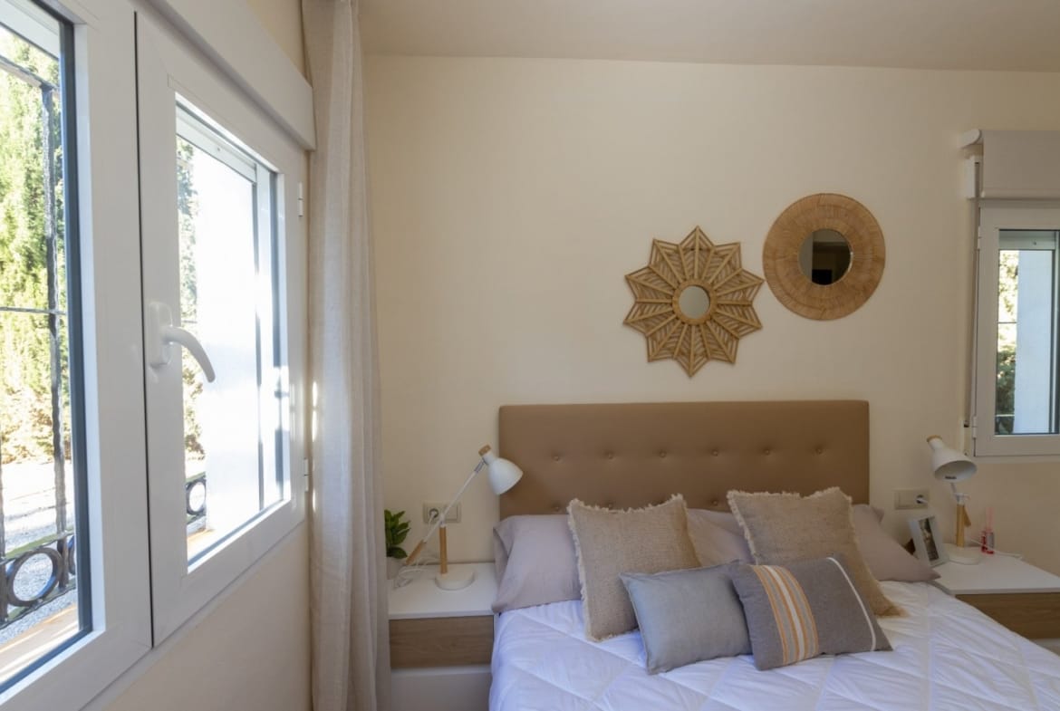 Double bed beside a window and wooden bedside table in Las Palas, Fuente Álamo, Murcia