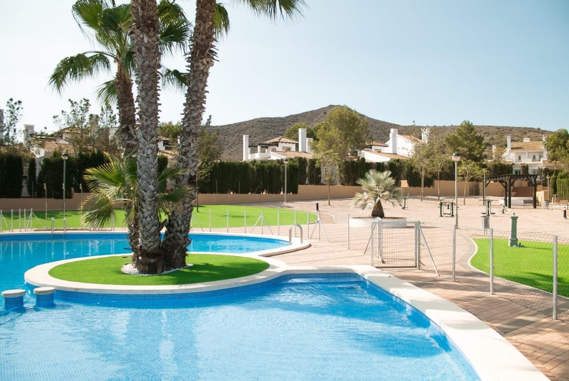 Communal swimming pool with palms and landscaped gardens in Las Palas, Fuente Álamo, Murcia