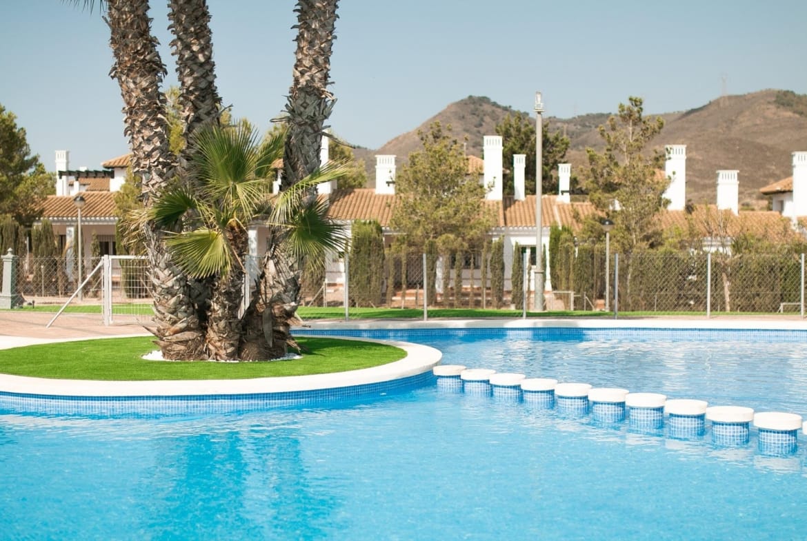 Communal pool with stepping stones and a palm-planted island in Las Palas, Fuente Álamo, Murcia