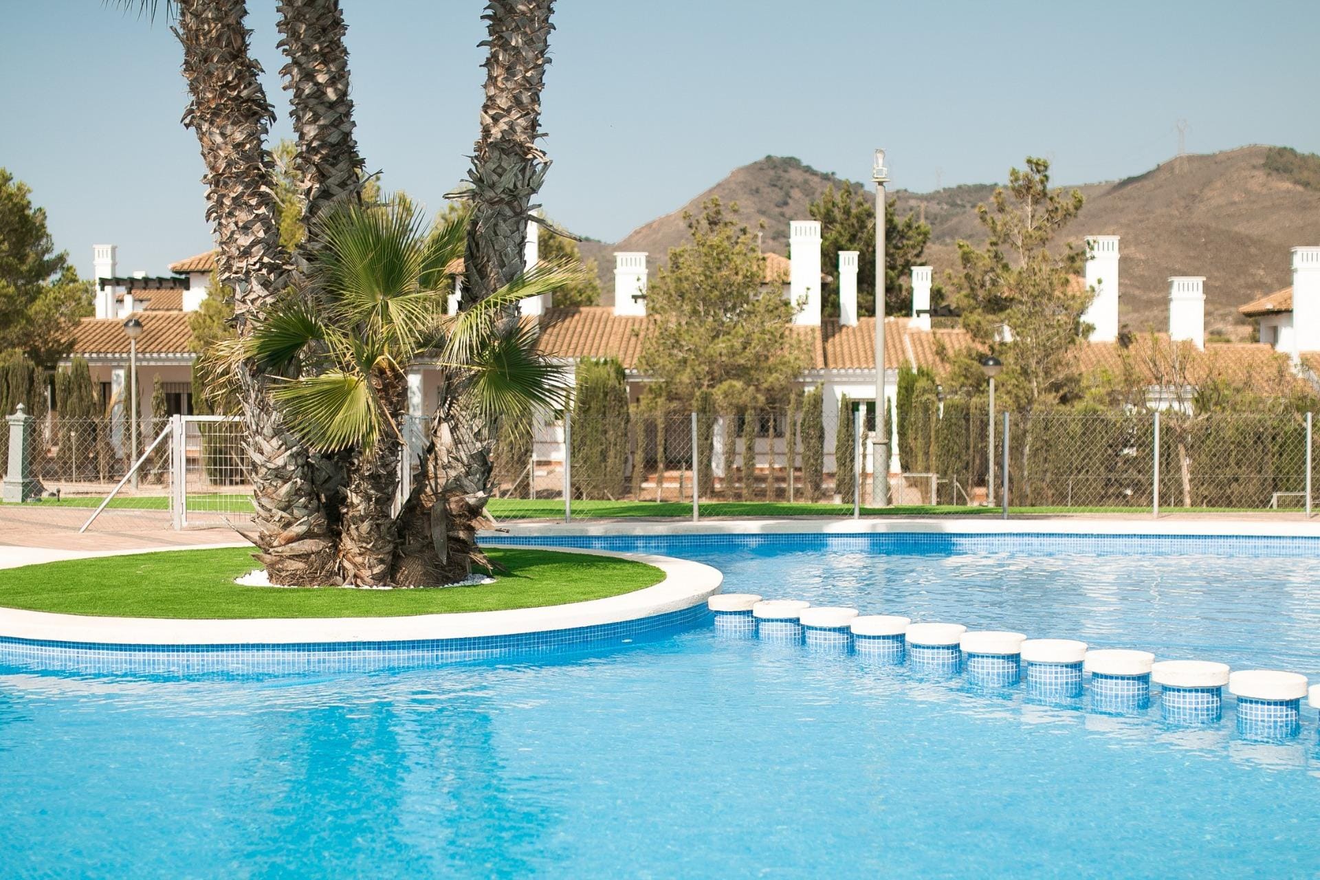 KEY-READY-VILLA-IN-FUENTE-ALAMO-MURCIA-39 Communal pool with stepping stones and a palm-planted island in Las Palas, Fuente Álamo, Murcia