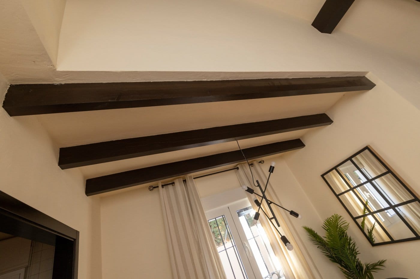 KEY-READY-VILLA-IN-FUENTE-ALAMO-MURCIA-9 Timber beams above a dining area with a window and mirror in Las Palas, Fuente Álamo, Murcia