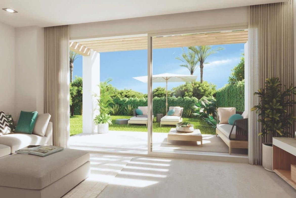 Living room with sliding glass doors opening onto a patio and garden in Sierra Cortina, Alicante