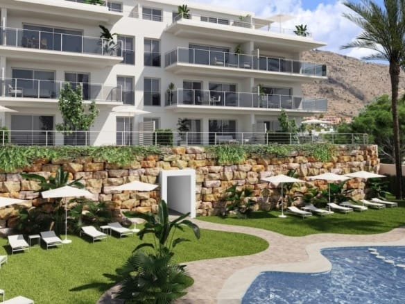Apartment balconies above a communal swimming pool, lawn and landscaped stone terraces in Sierra Cortina, Alicante