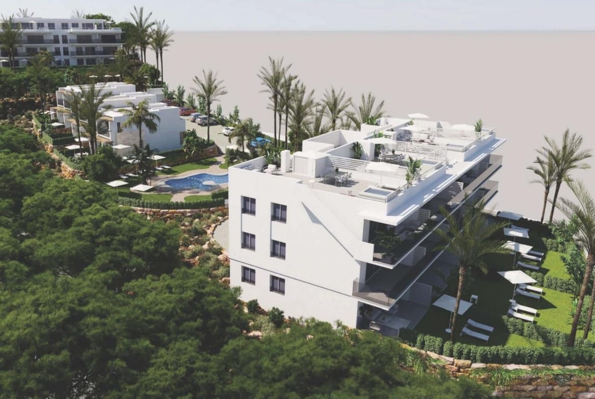 Aerial view of low-rise apartment buildings among landscaped gardens and palm trees in Sierra Cortina, Alicante
