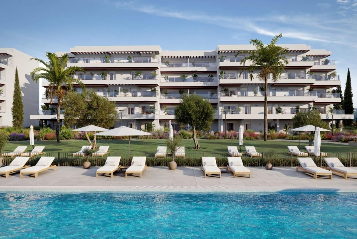 Communal swimming pool with sun loungers in front of the apartment buildings