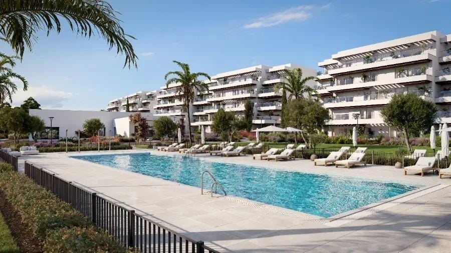 Long communal swimming pool with sun loungers and landscaped grounds in El Verger, Alicante