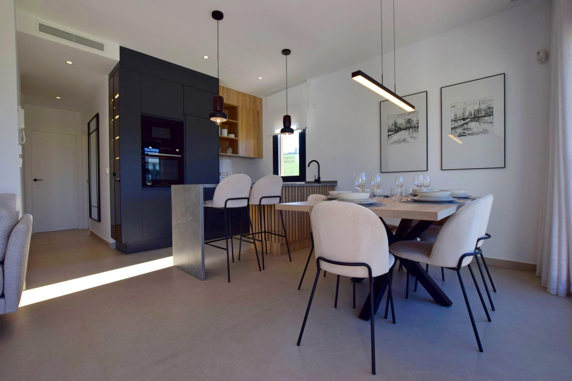 NEW-BUILD-APARTMENTS-IN-CONDADO-DE-ALHAMA-GOLF-COURSE-11 Dining space and kitchen with breakfast bar and pendant lighting
