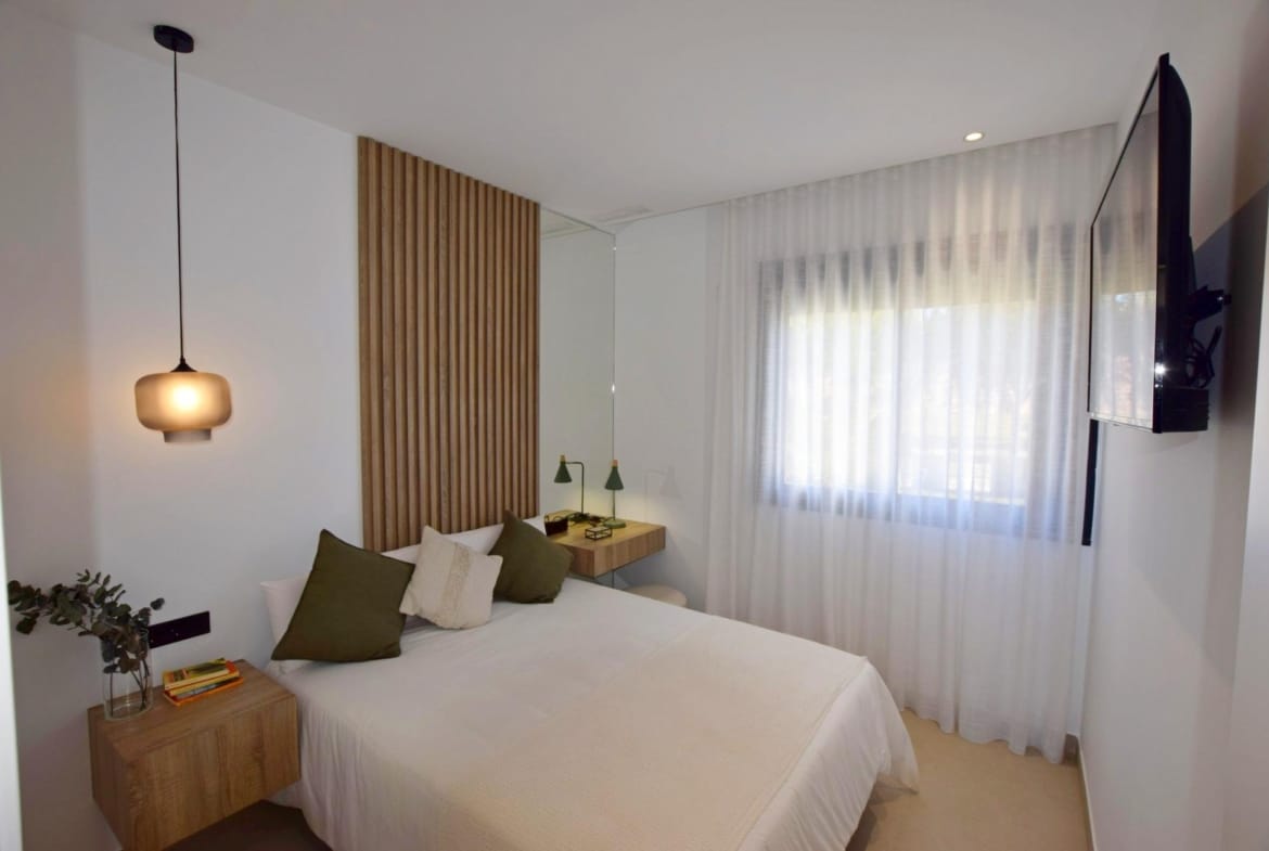 Bedroom with double bed, wall-mounted television and window