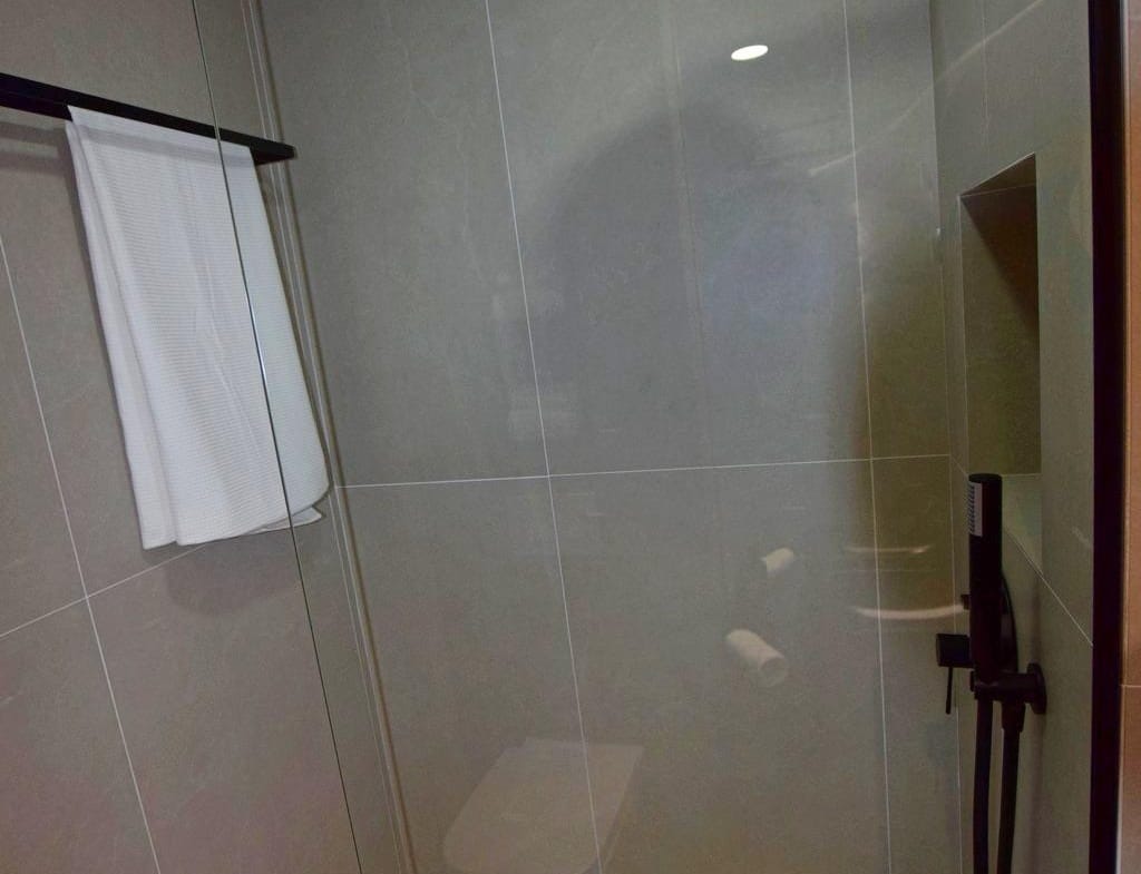 Walk-in shower with rainfall shower head and glass screen