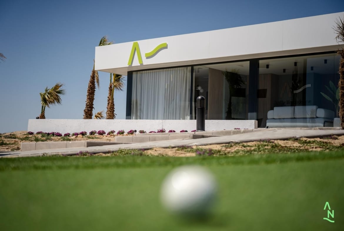 Modern pavilion beside the golf green with a ball in the foreground