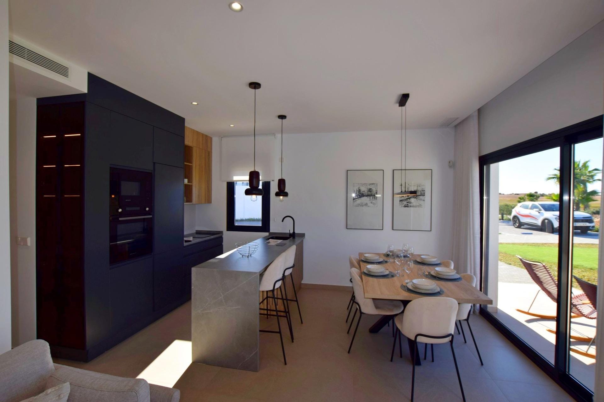 NEW-BUILD-APARTMENTS-IN-CONDADO-DE-ALHAMA-GOLF-COURSE-9 Kitchen with breakfast bar beside the dining area and large window doors