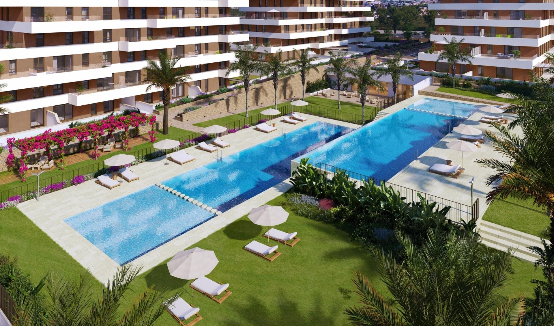Communal pools with sun loungers and palm-lined lawns in Playa del Torres, Villajoyosa, Alicante