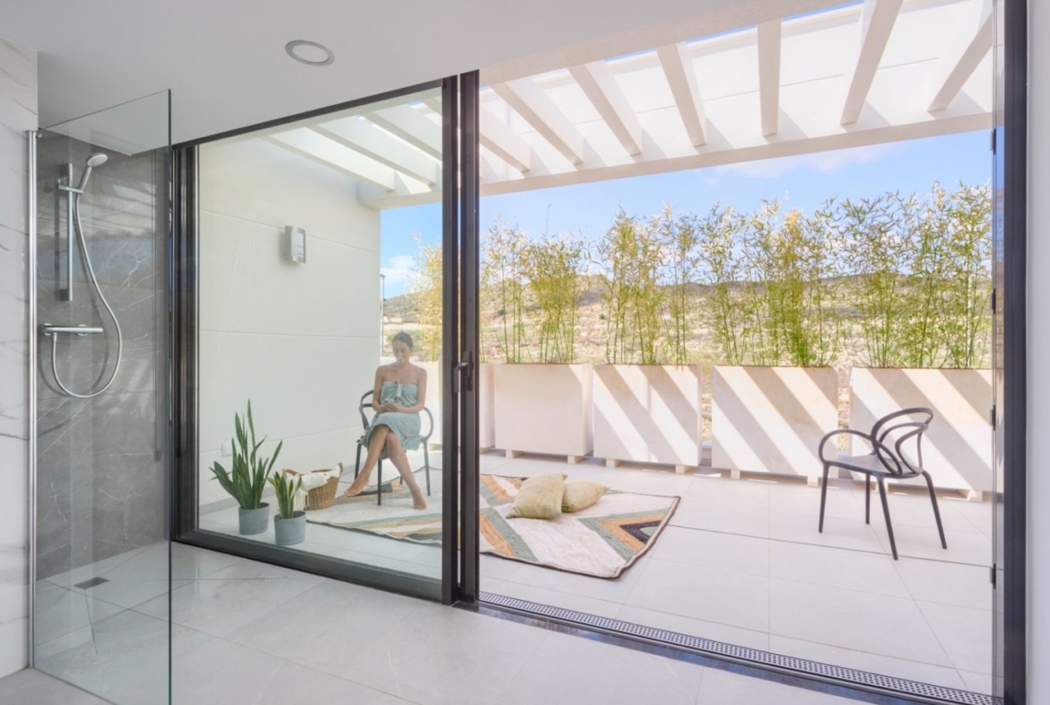 Covered balcony with glass balustrade, pergola shadows and view down to pool