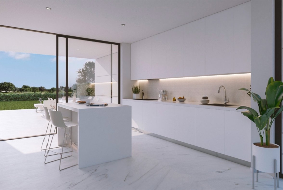 White minimalist kitchen with central island and large sliding doors onto terrace