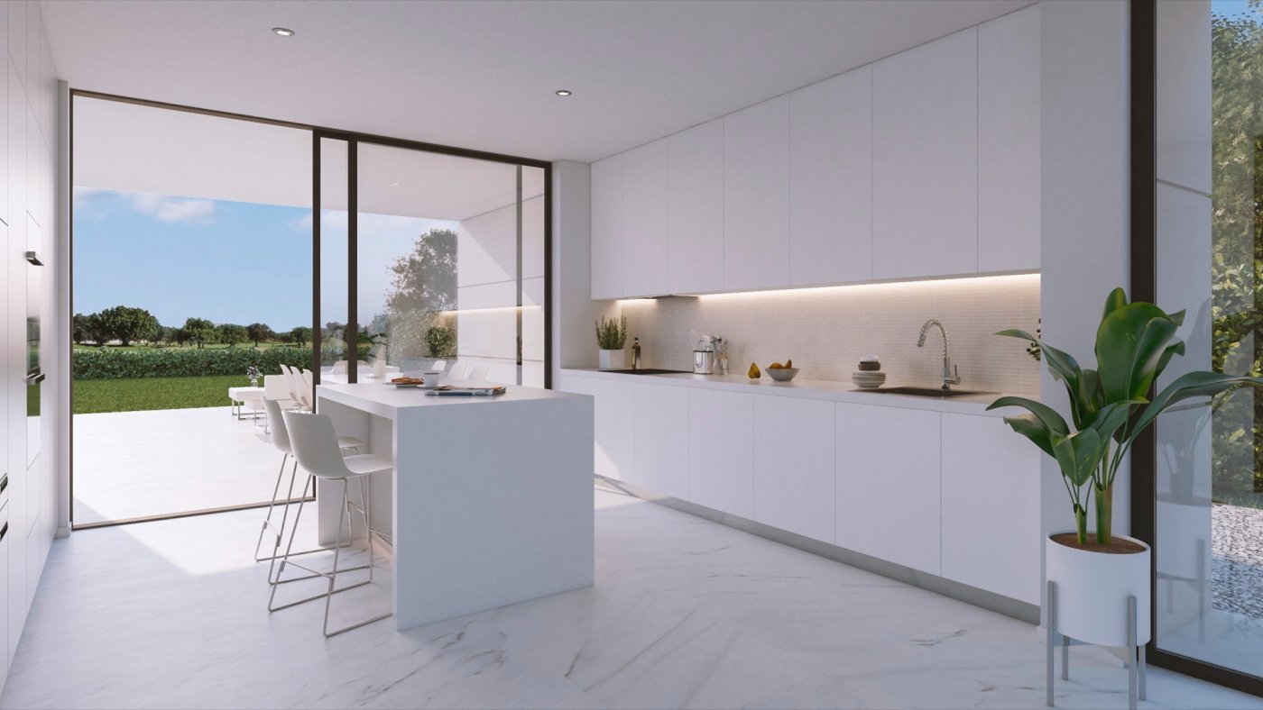 White minimalist kitchen with central island and large sliding doors onto terrace
