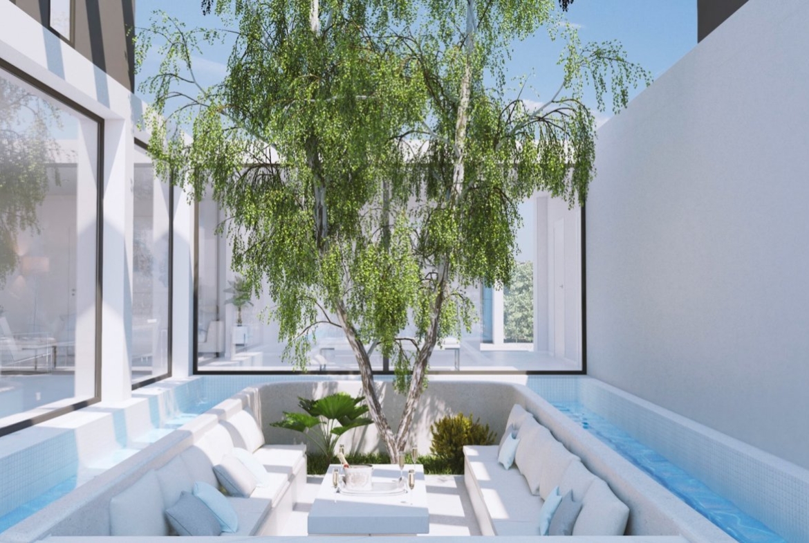 Sunken outdoor seating courtyard surrounding a small tree with water channel feature