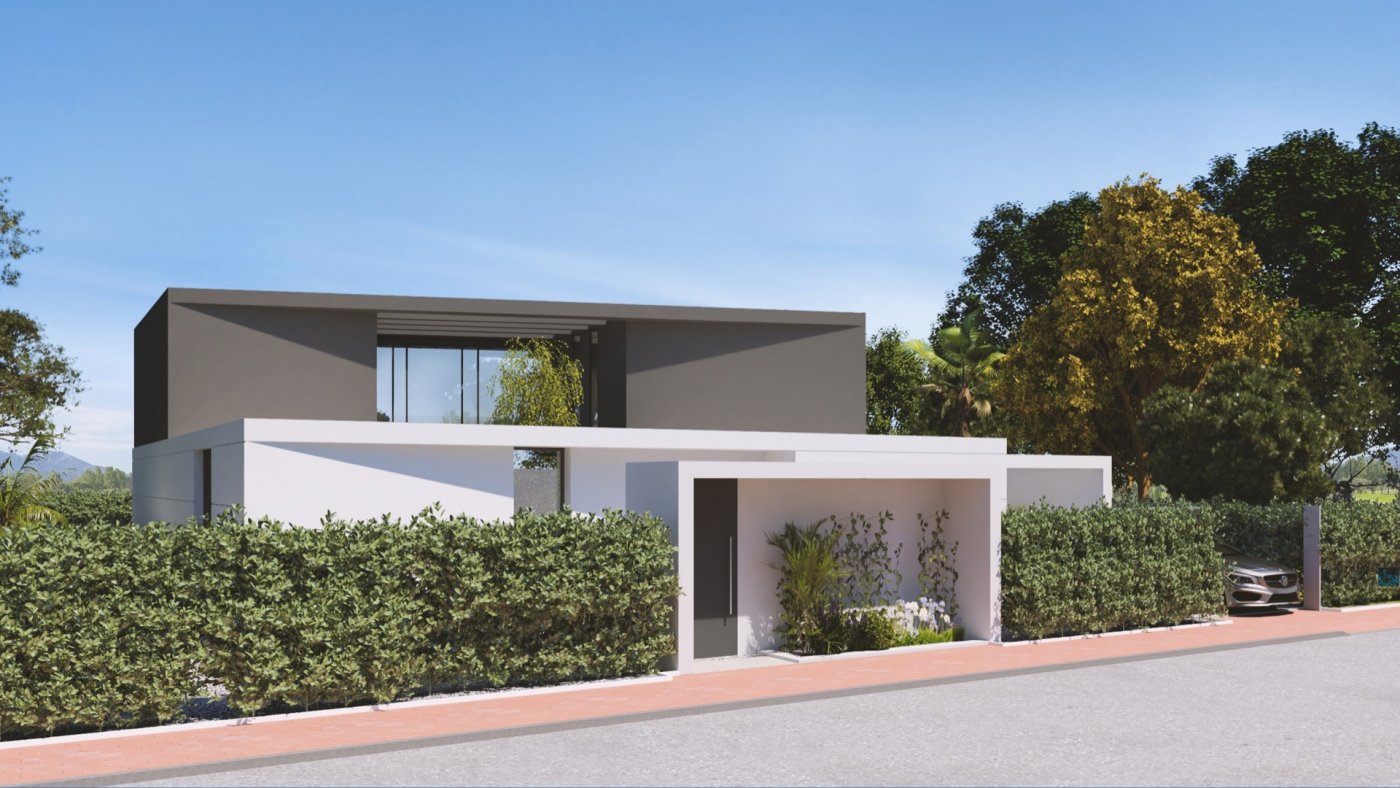 Angled street view of two-storey villa with driveway gate, entrance alcove and tall hedging