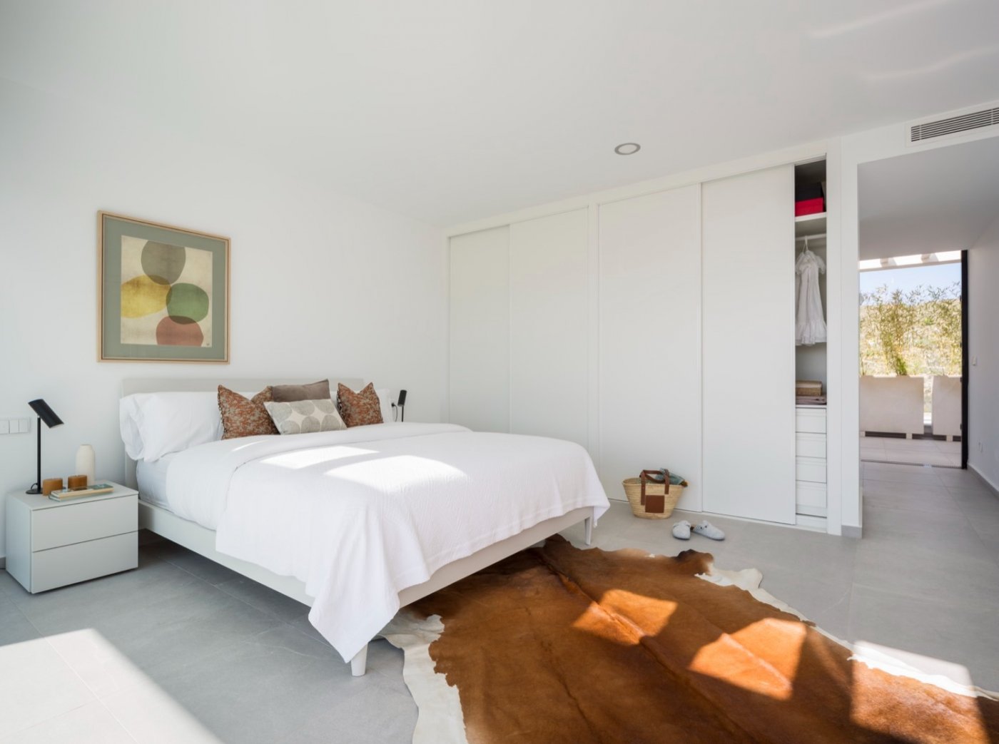 Bright bedroom with double bed, built-in sliding wardrobes and sunlight on floor