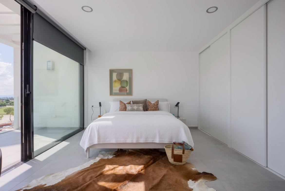 Bedroom with cowhide rug, sliding doors opening onto a small balcony