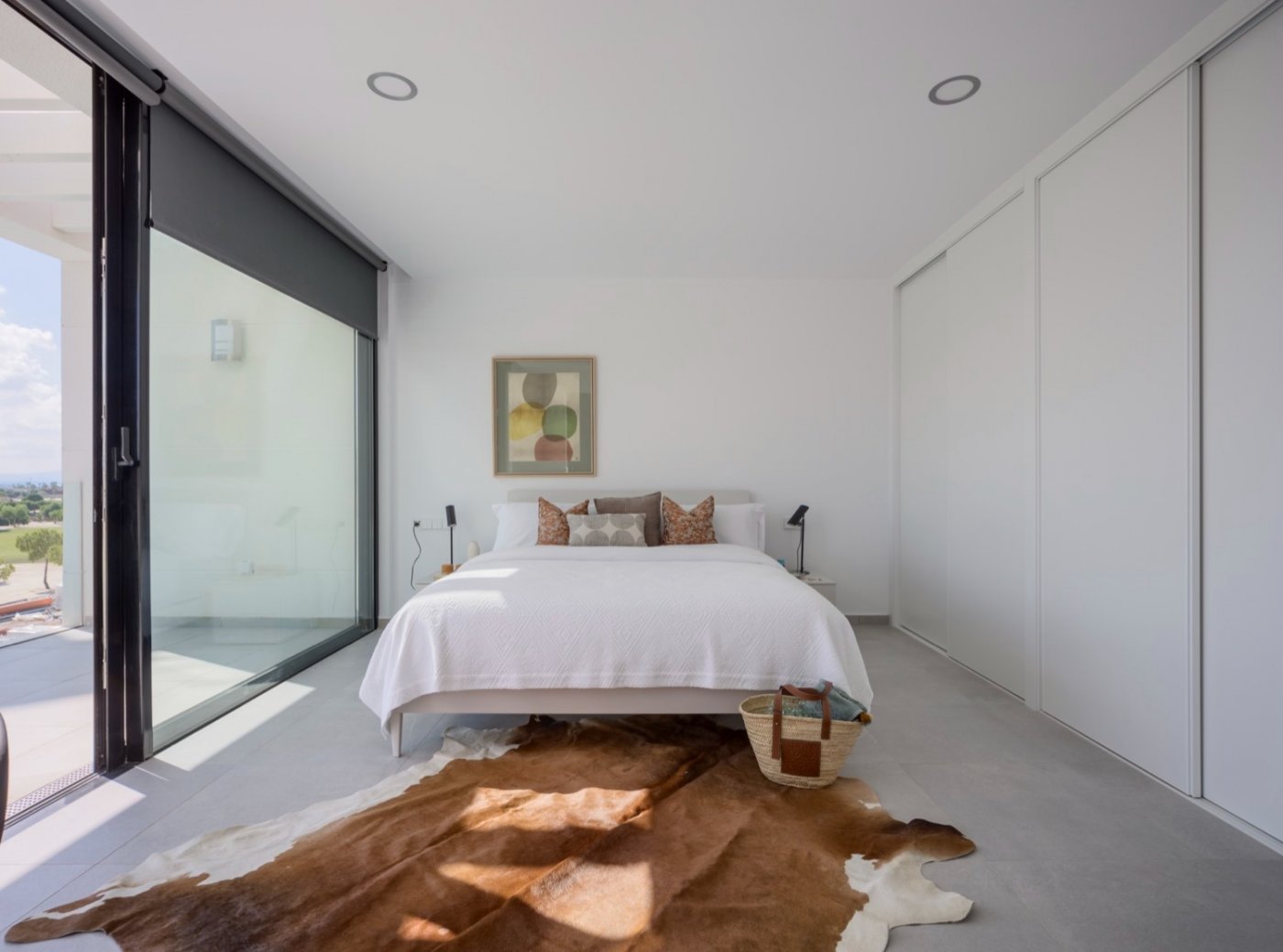 Bedroom with cowhide rug, sliding doors opening onto a small balcony