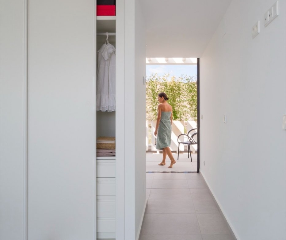 Hallway beside sliding wardrobes leading to an outdoor terrace with a figure