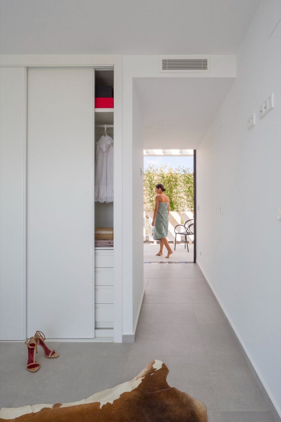 Hallway beside sliding wardrobes leading to an outdoor terrace with a figure