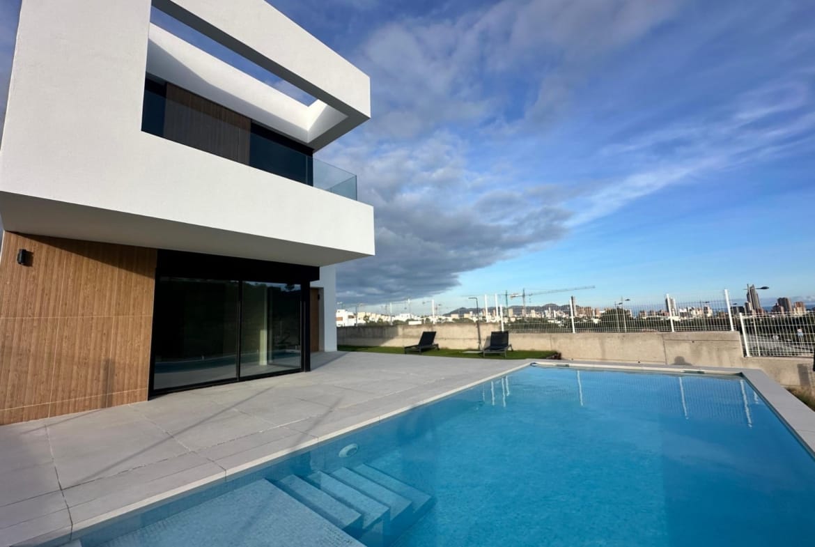 Swimming pool beside a white villa with timber-effect exterior accents in Finestrat, Alicante