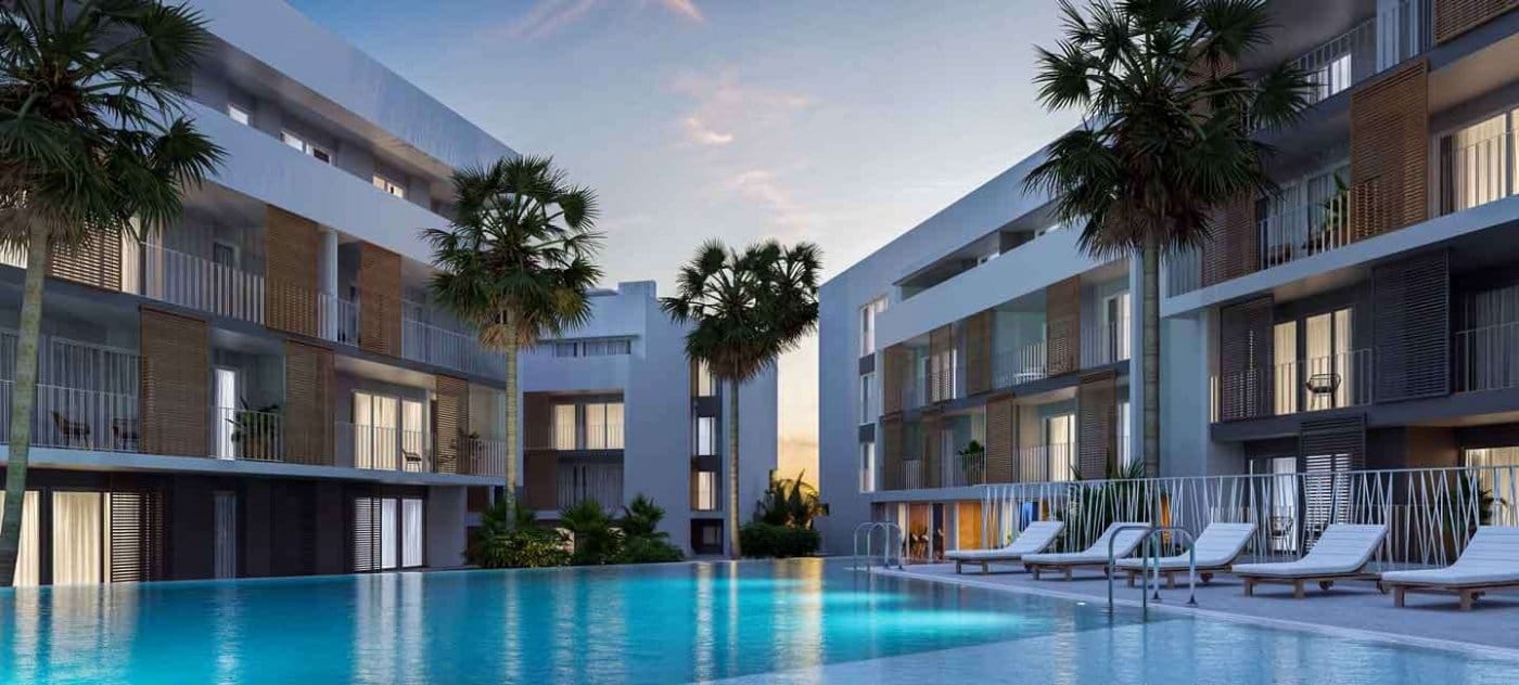 Evening rendering of the illuminated communal pool and surrounding apartment buildings in Jávea, Alicante