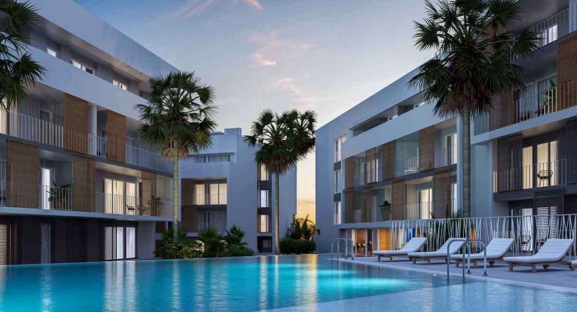 Evening rendering of the illuminated communal pool and surrounding apartment buildings in Jávea, Alicante